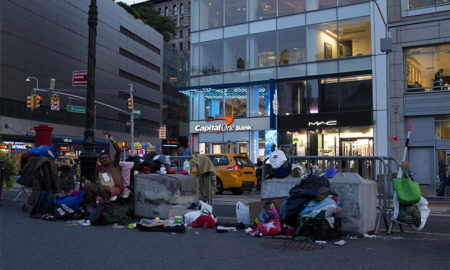 homeless: Clothes spread out in city gutter.
