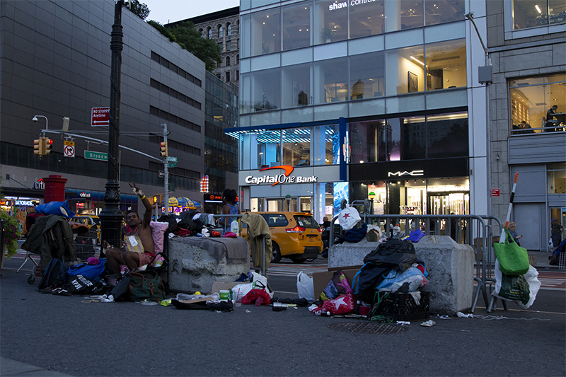 homeless: Clothes spread out in city gutter.