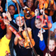 Oregon creative arts education grants; children with musical interest smiling at camera