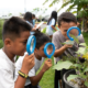 Oregon and Hawaii youth and environment grants; students looking at plants with magnifying glasses