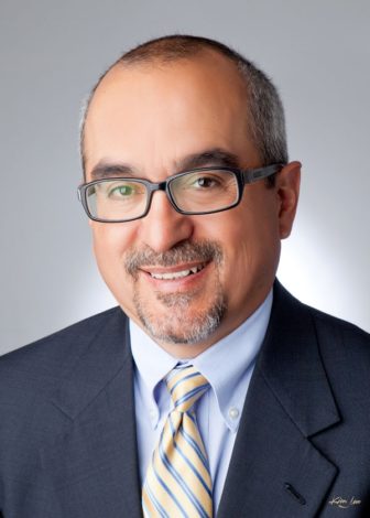 neglect: James Jimenez (headshot), executive director of New Mexico Voices for Children, smiling man with short graying hair, beard, mustache, glasses, wearing gray suit, light blue shirt, striped tie 