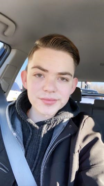 foster youth: Joseph Garcia (headshot), president of Leaders United Voices Youth Advocates of New Mexico, young man with short brown hair in car with seatbelt on wearing jacket over hoodie