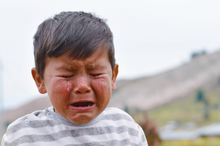 neglect: Little latino boy crying outdoors
