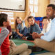 SEL: Elementary school kids and teacher sit cross legged on floor