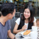 trafficking: Close-up of couple talking at cafe table with coffee cups and dessert