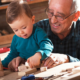 Relatives as parents support grants; grandfather playing with wooden blocks with toddler