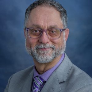 homeless: Smiling man with gray hair, beard, mustache, violet glasses, shirt, tie, gray jacket