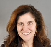 mentoring: Jean Rhodes (headshot), director of Center for Evidence-Based Mentoring at University of Massachusetts, smiling woman with long reddish hair, brown top