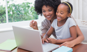 women and girls' support grants; young black mother and daughter happy on laptop