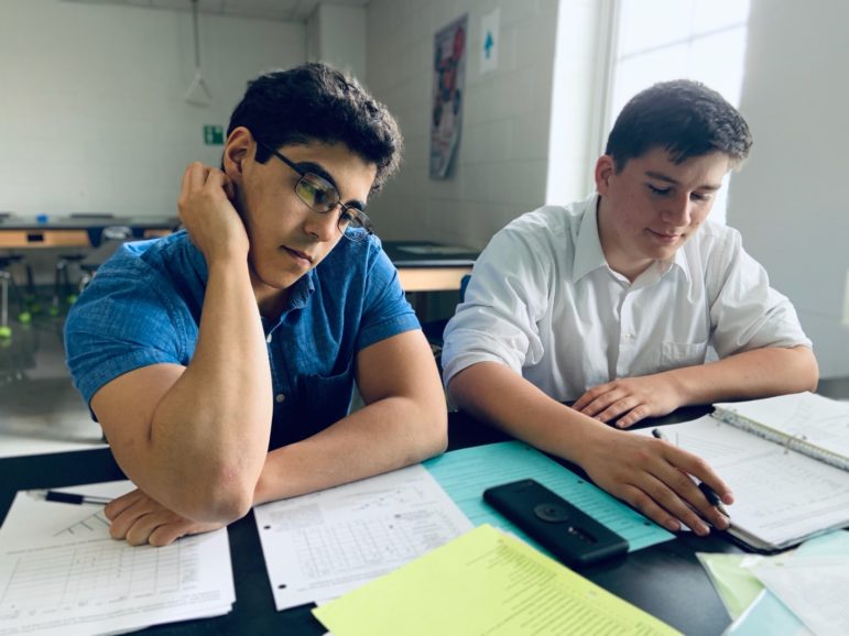 Alabama: 2 young men sitting at desk in school