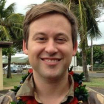 trauma: Jason Mallonee (headshot), on faculty at New Mexico State University’s School of Social Work, smiling man with short light brown hair, leis around neck