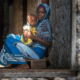 Early Estimates of Effects of COVID-19 Pandemic on Maternal and Child Mortality; Tanzanian mother and child sitting in hallway
