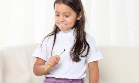 trauma: Little girl holding a paintbrush