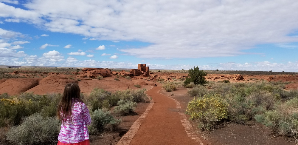Native American: A child walking down a path to view ruins.