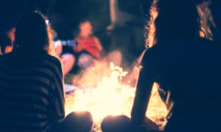 crip camp: People sit at night around a bright bonfire.