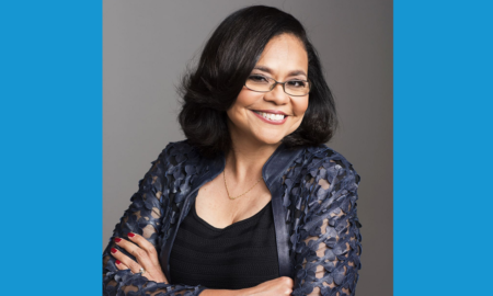 Dr. Kimberlyn Leary newsmaker headshot; woman of color wearing glasses with arms crossed and smiling