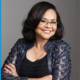 Dr. Kimberlyn Leary newsmaker headshot; woman of color wearing glasses with arms crossed and smiling