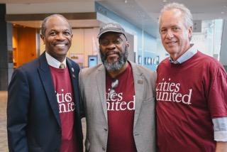 3 smiling men pose wearing maroon Cities United T-shirts