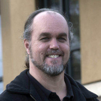 trauma: John Lash (headshot), was director of Georgia Conflict Center, smiling balding man with graying beard, mustache