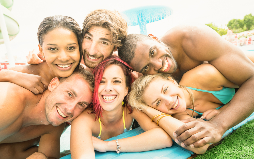 emerging adults: 6 guys and girls taking selfie, heads stacked together