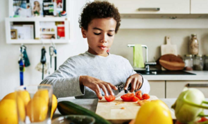 healthy food access, Childhood hunger grants; young child preparing healthy food in kitchen