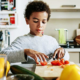 healthy food access, Childhood hunger grants; young child preparing healthy food in kitchen