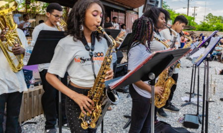 creative youth development music program grants; group of young black students playing brass instruments on stage