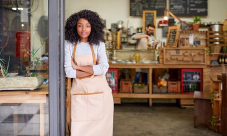 Low-Income Community Minority-Owned Business Support grants; young black woman stands at the front of her shop