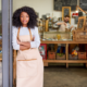 Low-Income Community Minority-Owned Business Support grants; young black woman stands at the front of her shop