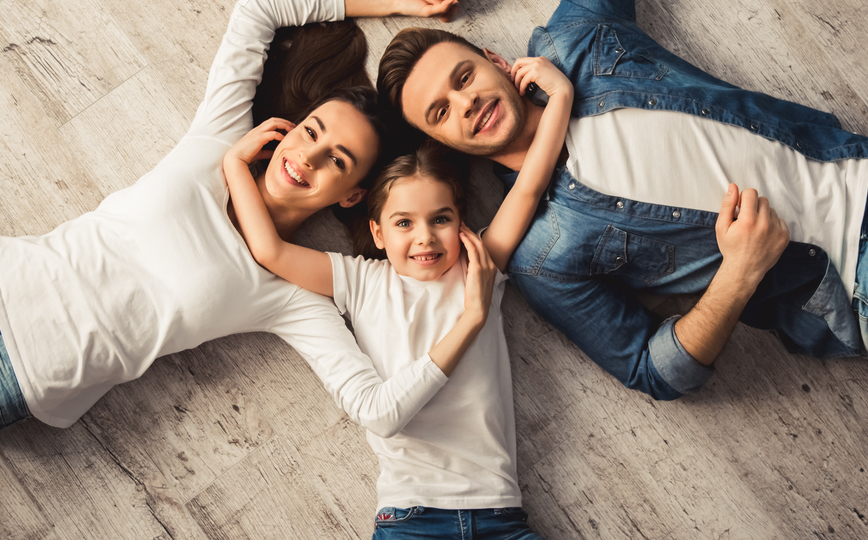 Minnesota grant, family economic mobility and health; young happy family laying on the floor