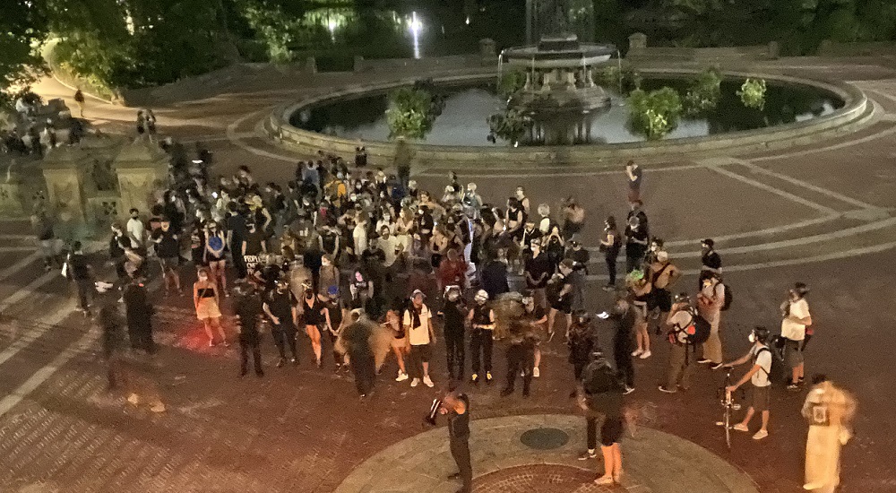 warrant squad: Overhead view of spread-out group of people outside near fountain at night