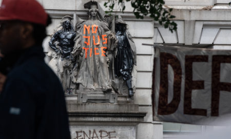 NYPD: Sculpture on building has no justice written on it with orange tape, graffiti below it