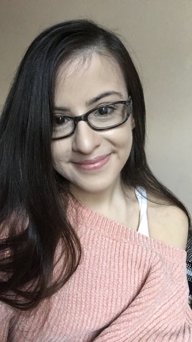 disabilities: smiling woman with long brown hair, glasses, peach off-the-shoulder top