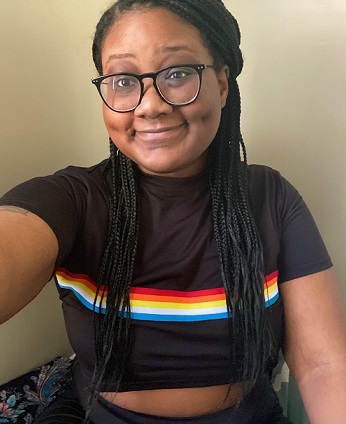 employment: Woman with dark black braids, glasses in crop top with bright stripes