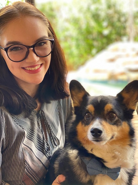 employment: smiling woman with brown hair, glasses, striped shirt, holding dog in lap