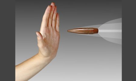 gun violence: hand held up to stop speeding bullet