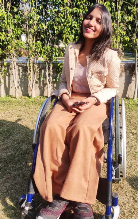 telemedicine: smiling woman in wheelchair wearing peach-colored outfit, sneakers
