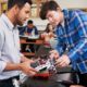 North Carolina STEM Educator grants; Teacher With Male Pupils Building Robotic Vehicle In Science Lesson