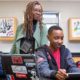 Racism and racial justice education grants; black teacher helping students on computers