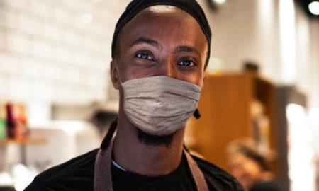 NYC minority owned small business relief grants; black business owner working with facemask on