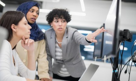 youth fields workforce, mentoring: 3 women, one wearing a hijab, look at computer screen together