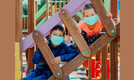 afterschool: children wearing protective masks playing on playground
