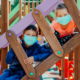 afterschool: children wearing protective masks playing on playground
