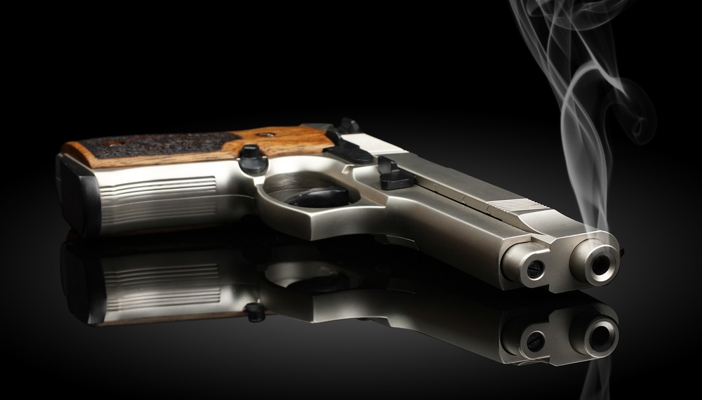 gun violence: Chromed handgun on black background with smoke