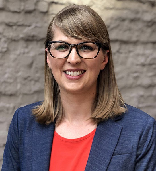 Chelsea Parsons (headshot), vice president of gun violence prevention at American Progress, smiling woman with light brown hair, glasses, blue blazer, tomato-colored top 