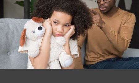 child abuse: Young Black girl closing ears ignoring angry strict Black dad scolding