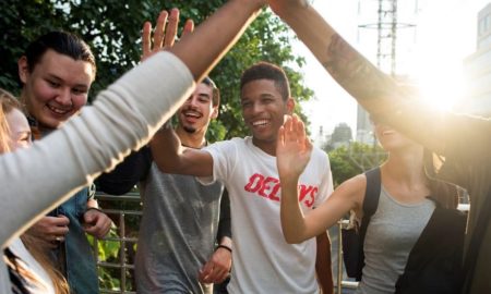 youth mental health grants; young people high-fiving smiling