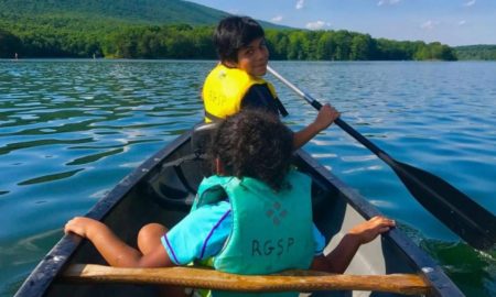 environmental education and restoration grants; two children paddling canoe in lake