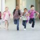 Group Of Elementary Age Schoolchildren Running Outside