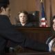 child sex crime: Woman in witness stand being cross-examined with judge nearby